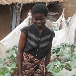 基貝拉貧民窟的Alice Atieno和家門口自己種植的蔬菜合影。（照片由Miriam Gathigah/IPS提供）。