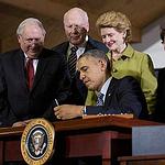 美國總統歐巴馬在密西根州立大學簽署2014年農業法。歐巴馬後方著綠衣者為參議員Debbie Stabenow。攝於2014年2月7日（照片由USDA提供）。