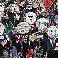 抗議民眾組成遊行隊伍，高舉旗幟與人偶 :: 照片來源：Indymedia Germany