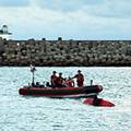 一組海岸防衛人員在考愛島諭令以游泳及乘浪板方式抗議「夏威夷超級渡輪」抵達的人士。圖片來源：CNN