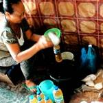 一名巴里島婦女正用塑膠瓶回收食用油(照片節錄自雅加達郵報)