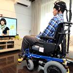 藉由Brain・Machine・Interface運作的電力輪椅，不需用到雙手就能操縱地電視開關。(摘錄自朝日新聞，高橋一德攝)