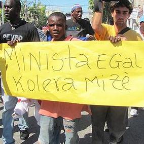11月10日，在太子港示威反對聯合國維和部隊。牌子上寫著：「聯合國駐海地穩定特派團(MINUSTAH)等於霍亂和痛苦。」圖片節錄自：Gaetantguevara相本。