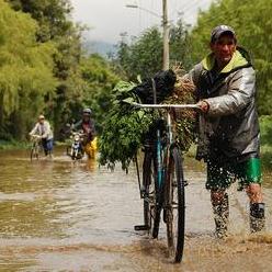 2010年11月17日，波哥大的居民在淹水道路行走的景象。圖片節錄自：Santiago La Rotta相本。