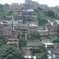 從委內瑞拉首都卡拉卡斯國際機場，因對外的公路中斷而繞行山區，大量沿著山邊密集建築的房子，為所謂的貧民區。