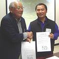 台灣環境資訊協會秘書長陳瑞賓與明日香景觀保存志工協會會長三木健二交換合約。