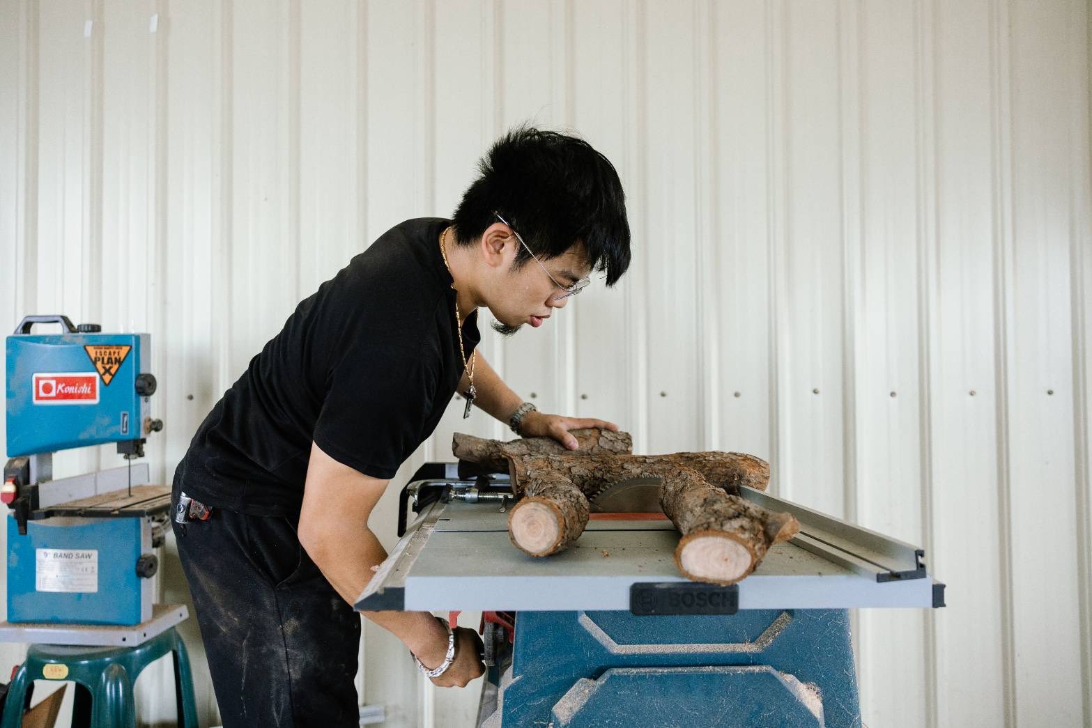 張嘉哲於工作室進行木材加工，將領用回來的行道樹修枝木轉化為家具與生活器物。