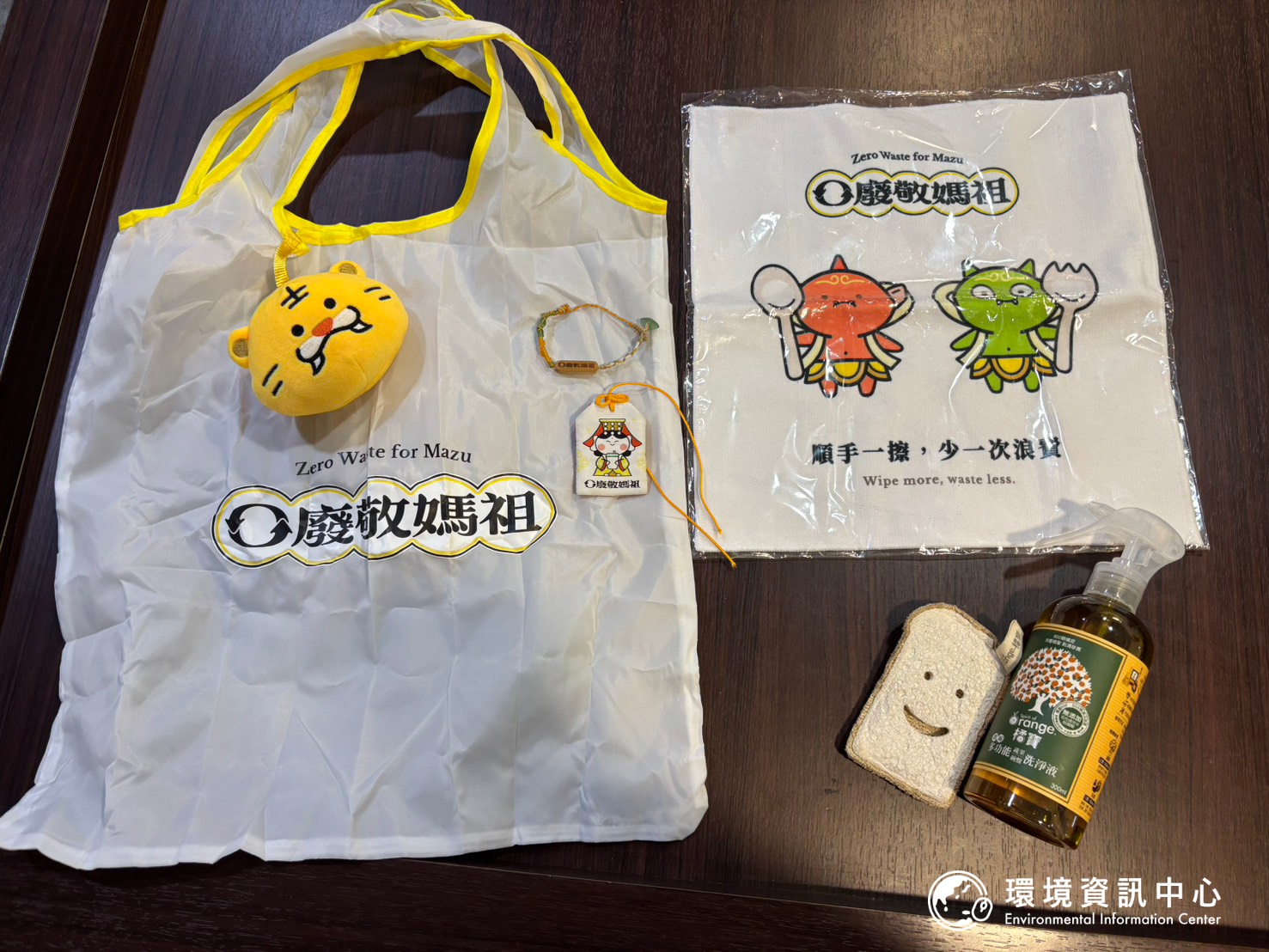 零廢敬媽祖的福袋，同時也是募資計畫的回饋品，包含虎爺環保袋、海廢手環等。圖片右下角為廠商贊助的洗碗精與造型菜瓜布，供民眾清洗餐具。攝影：林昱妍