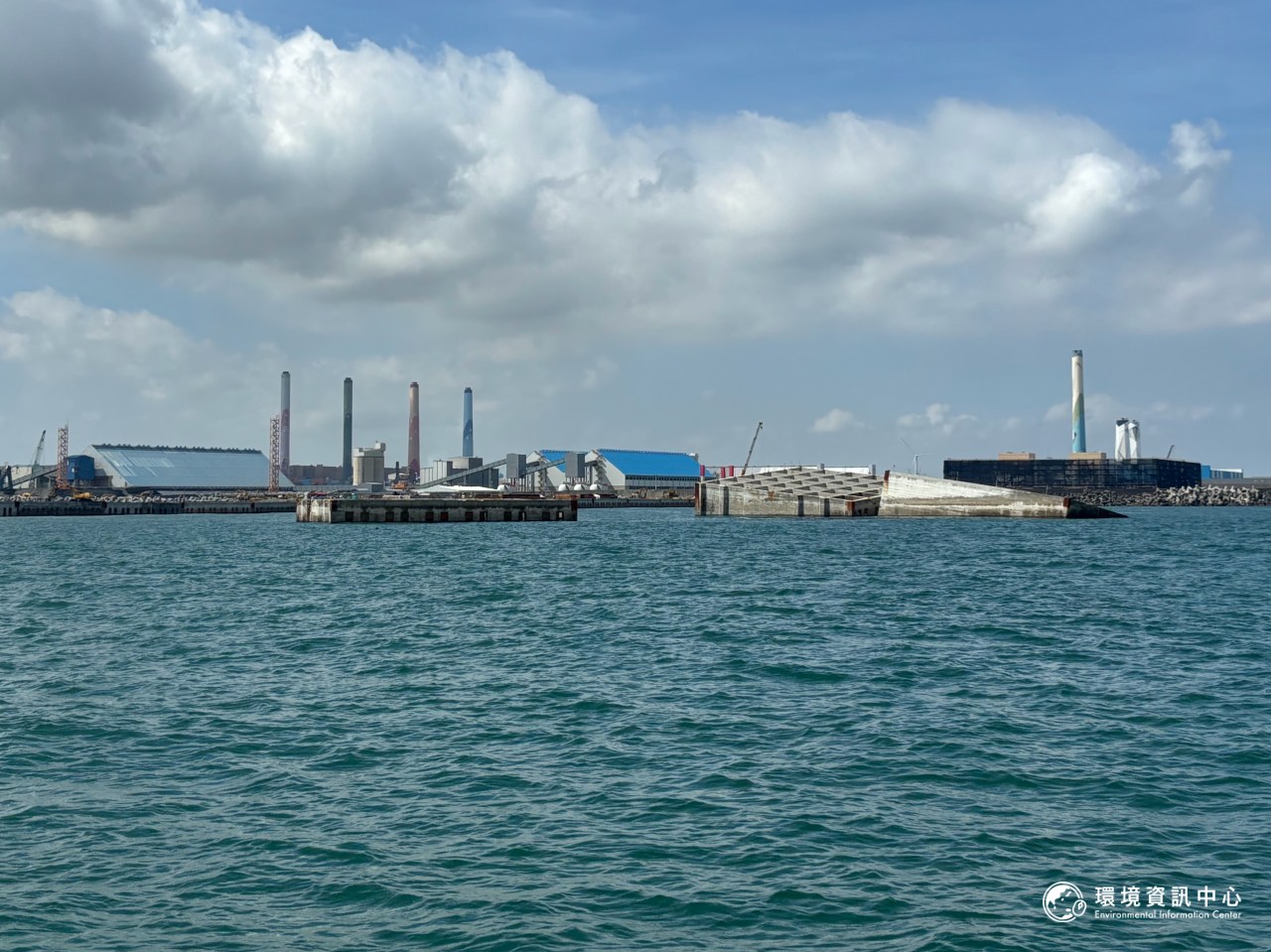 台中港新建填方區海堤工程放置沉箱(圖中網格狀磚塊),後方是台中火力發電廠的標誌煙囪。攝影:林昱妍