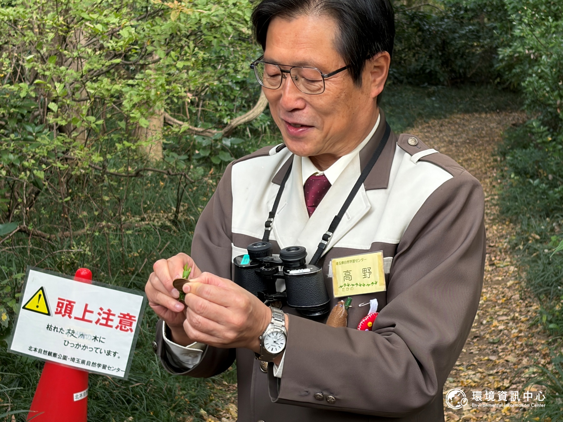 高野先生撿起地上的葉子，現場示範用酸性葉片將硬幣擦亮。攝影：陳立炘