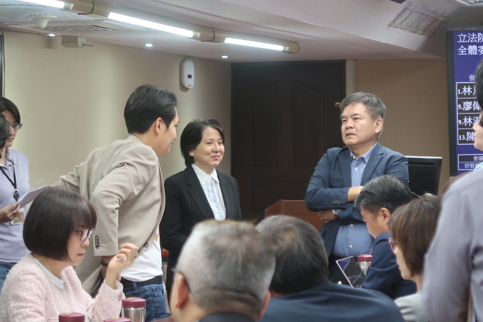 空污法修法審議會前，國民黨立委羅廷瑋、民眾黨立委邱慧洳和民進黨立委莊瑞雄（左至右站立三人）溝通是否先開公聽會等事項。攝影：林昱妍
