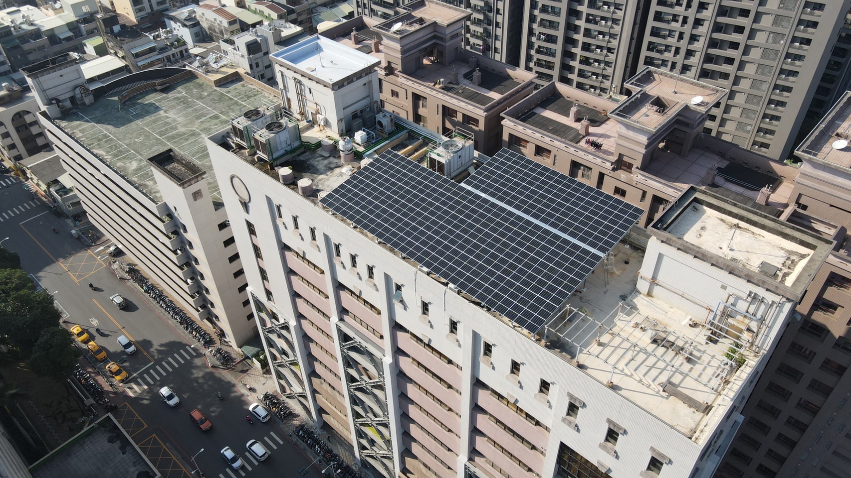 高雄市2012年開始,即透過《高雄市綠建築自治條例》,要求一定規模的公有新建物、高樓新建物、新都更案、容積移轉案及工廠等,請照時必須裝設一定比例太陽光電或綠屋頂。圖為高雄苓雅行政中心頂樓的光電設施。圖片來源:郭軒甫提供