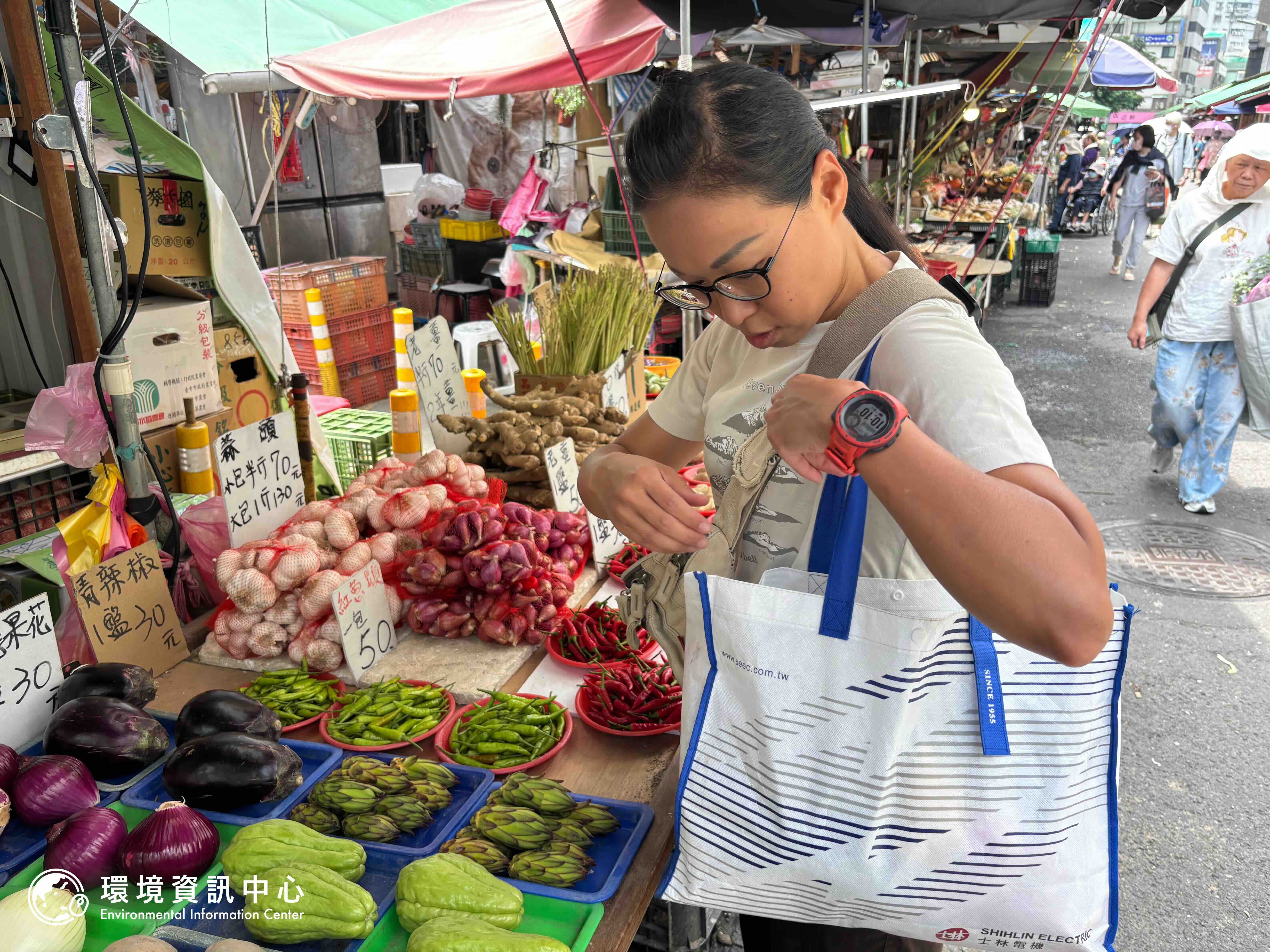 林映如於永春市場購物，買下少見的火龍果花苞回家料理，也全程自備購物袋與容器盛裝戰利品。攝影：林昱妍