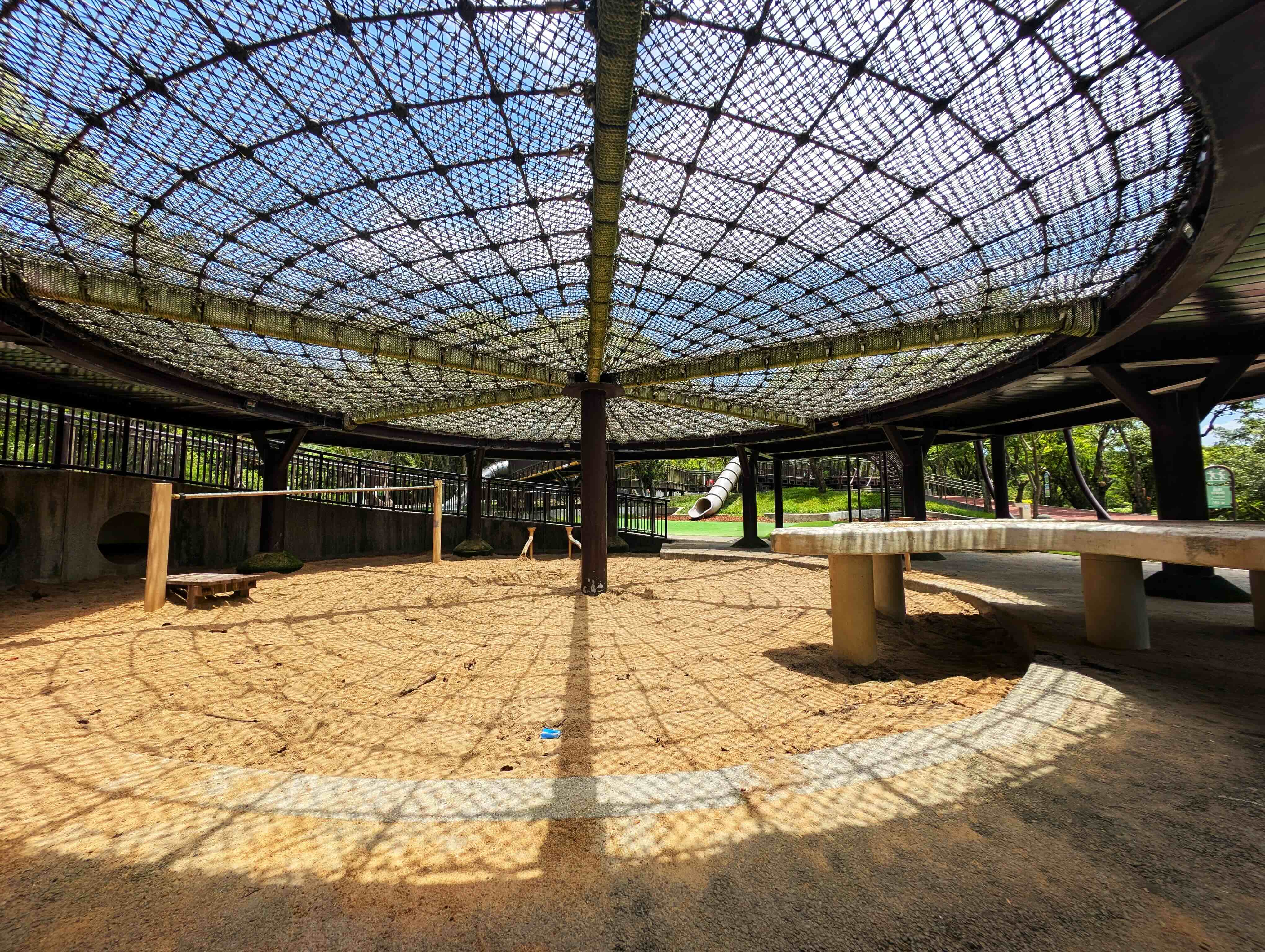 公園裡面，遊戲區通常是最熱的區塊，不過南港公園在沙坑上方裝設麻繩，除了作為遊具，也可以有效形成遮蔽、降低孩子玩耍時的熱傷害風險。攝影：陳昭宏