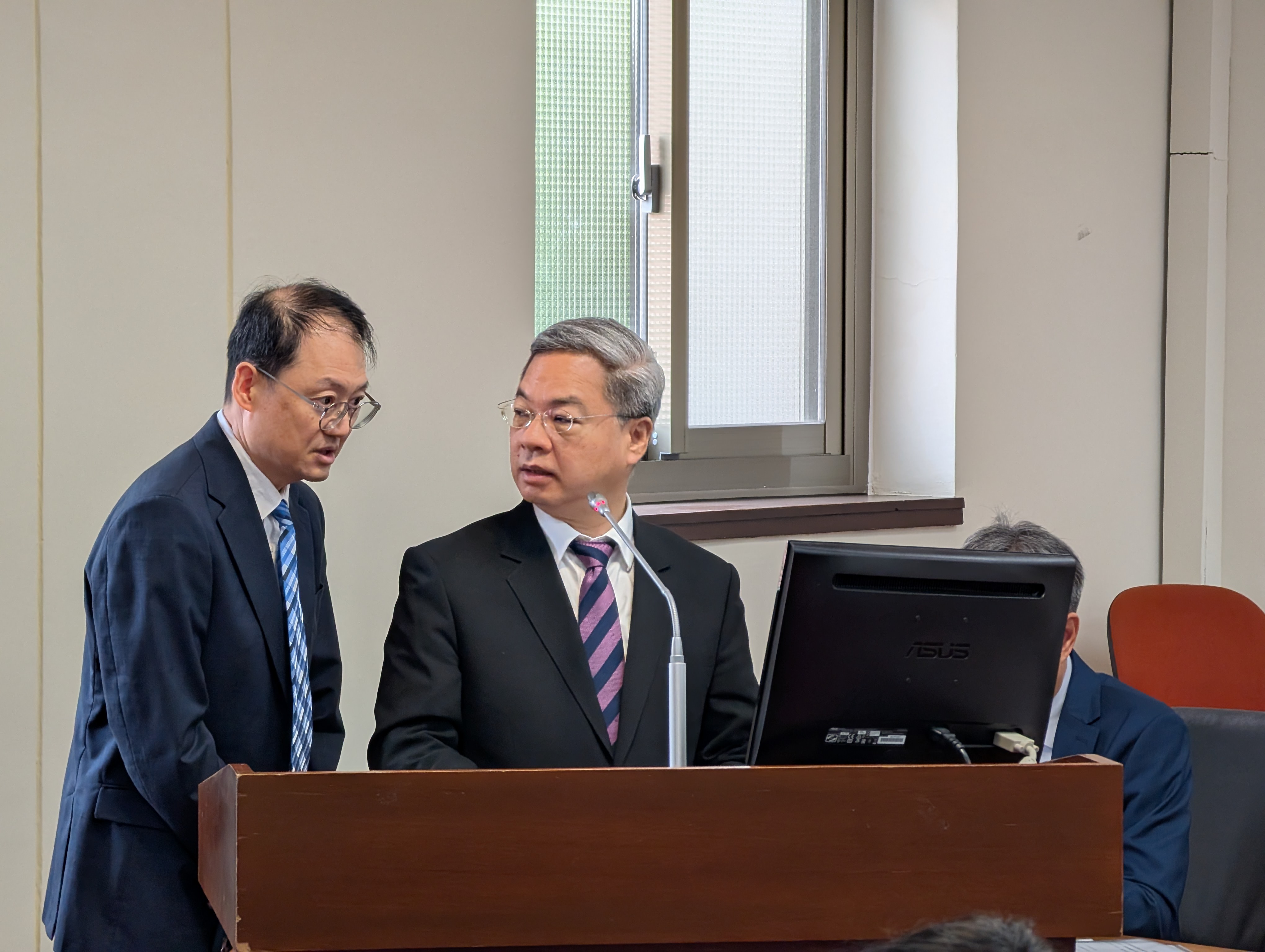 經濟部長龔明鑫（右）今（16）日在立院備詢時，與能源署代理署長吳志偉（左）討論。攝影：陳昭宏