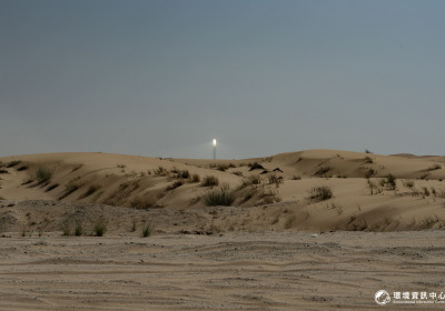 筆直的道路往沙漠的深處前進，遠方一座太陽能公園的聚光塔頂端白光環繞，在大白天中依舊耀眼。